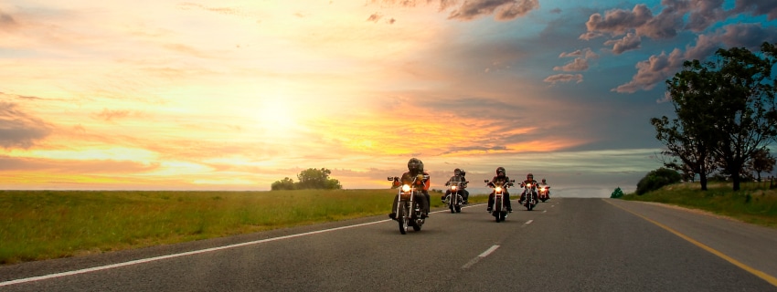 Bikers riding away from the sunset