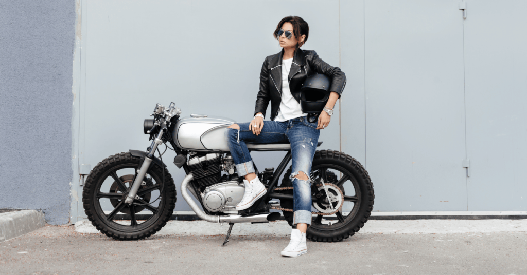 Cool woman sitting on motorcycle with helmet on her hand