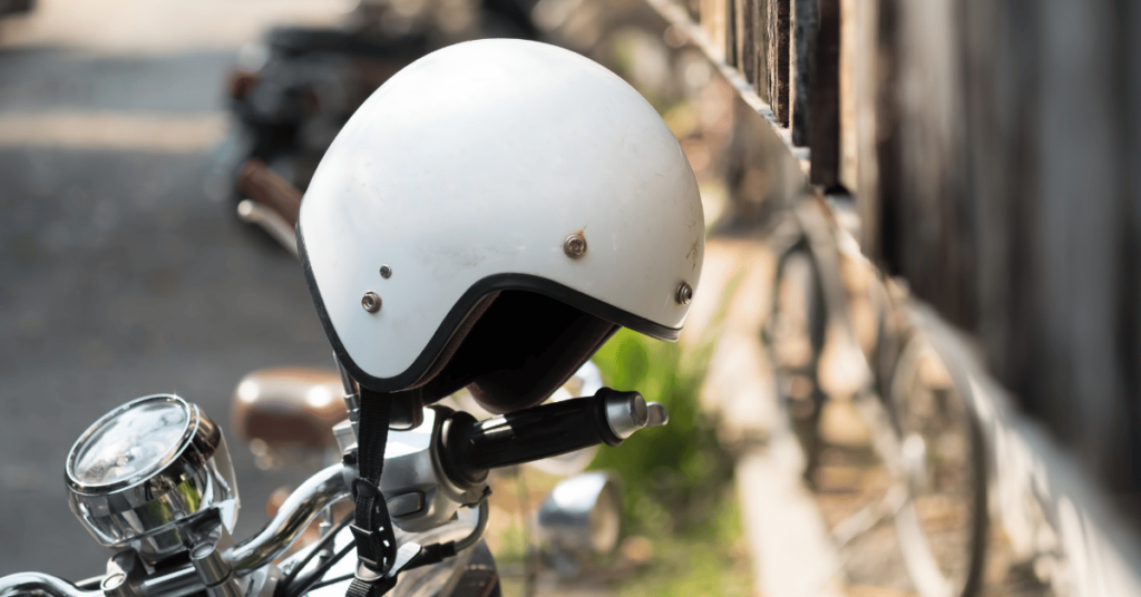 A helmet hanging on a parked motorcycle wheel