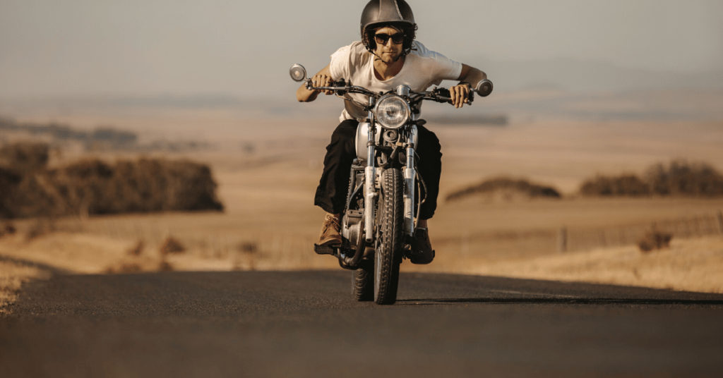 Male rider dressed well with a helmet on, riding motorcycle in Utah roads