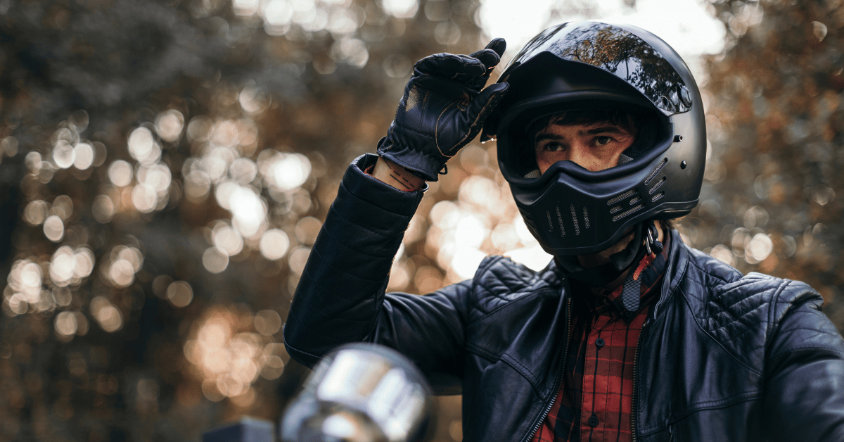 Male motorcyclist, wearing helmet, gloves and a jacket, sitting on his motorcycle. Ready to ride!
